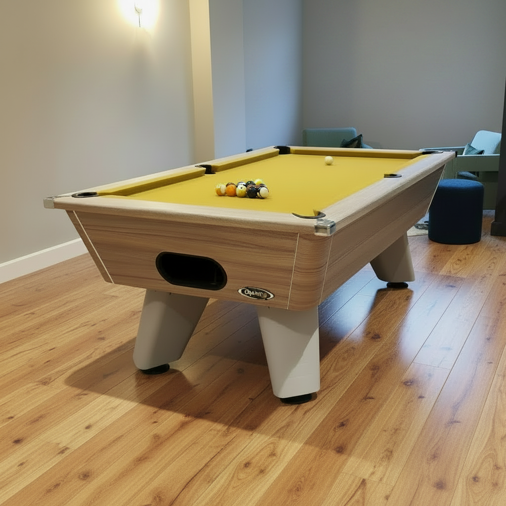 wood Pool table with yellow cloth on a wooden floor in a room with a window.